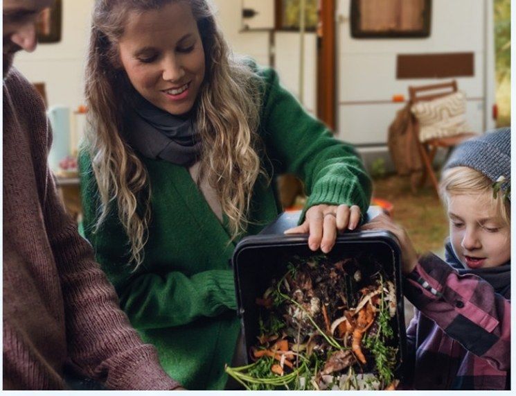 Une famille dépose des restes de table dans un bac à compost